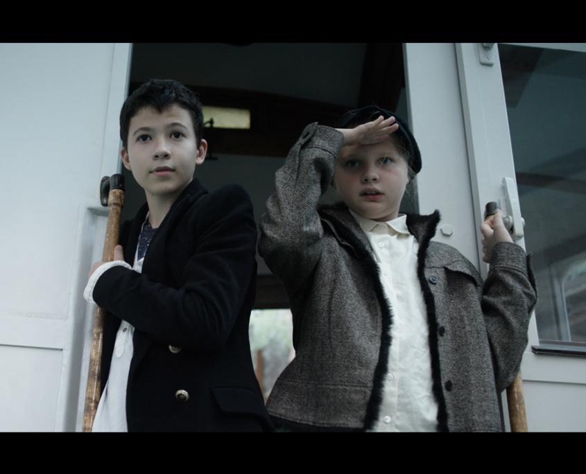 Zwei junge Schauspieler in der Tür eines fahrenden Zuges
